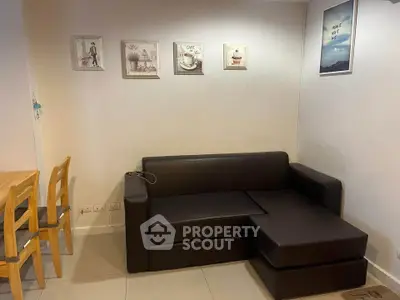 Cozy living room with modern black sofa and stylish wall art, perfect for relaxation.