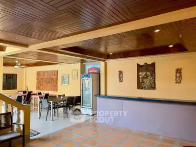 Spacious open-plan living area with wooden ceiling and artistic decor