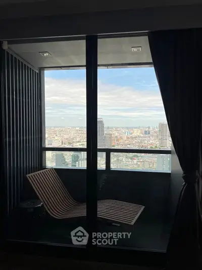 Stunning high-rise balcony with panoramic city view and modern lounge chair.