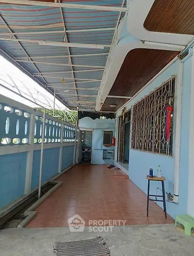 Charming covered balcony with tiled flooring and decorative railing, perfect for relaxation.