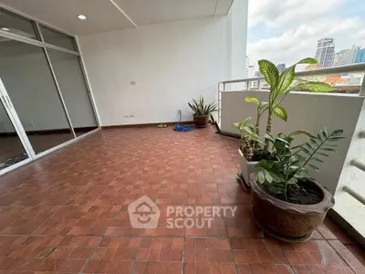 Spacious balcony with city view and potted plants, perfect for relaxation.