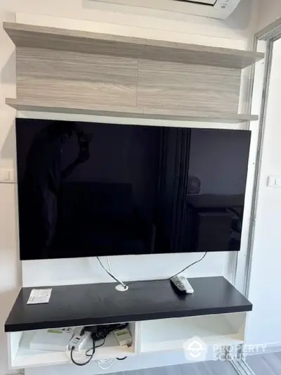 Modern living room with wall-mounted TV and sleek storage unit