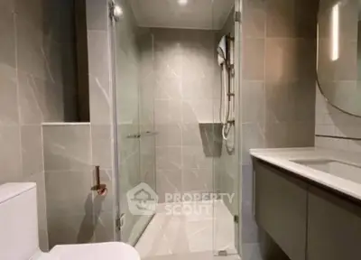 Modern bathroom with glass shower enclosure and sleek fixtures.