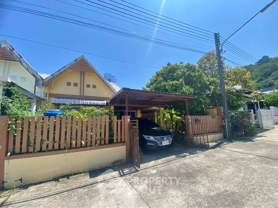 Charming suburban house with carport and lush greenery in a peaceful neighborhood.