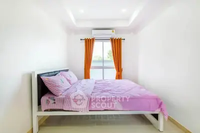 Bright bedroom with pink bedding and orange curtains, featuring a window view and air conditioning.