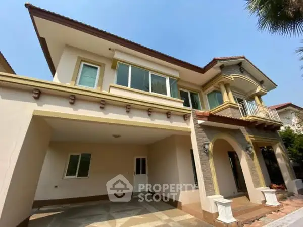 Elegant two-story house with spacious driveway and charming balcony.