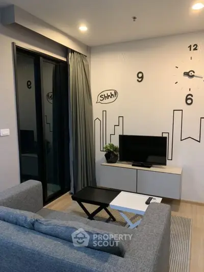 Modern living room with stylish decor and wall clock, featuring a cozy sofa and TV setup.