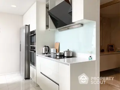 Sleek modern kitchen with stainless steel appliances, white cabinetry, and a minimalist design in a bright interior space.