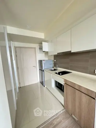 Modern kitchen with sleek cabinets and compact design in a contemporary apartment.