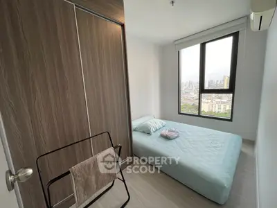 Cozy bedroom with city view, featuring a minimalist design and ample natural light.