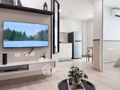 Modern living room with wall-mounted TV and sleek kitchen area
