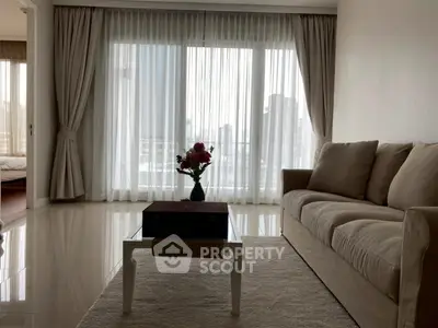 Elegant living room with plush sofa and city view through large windows