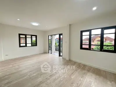 Spacious bright living room with large windows and balcony access