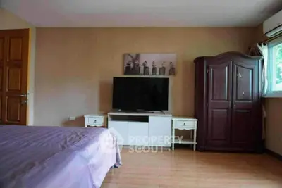 Spacious bedroom with modern TV and elegant wardrobe, perfect for relaxation.