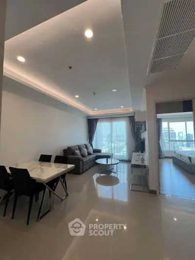 Spacious modern living room with city view, elegant furniture, and natural light.