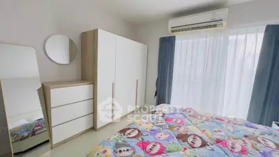 Bright bedroom with modern furniture and colorful bedding, featuring a large window and air conditioning.