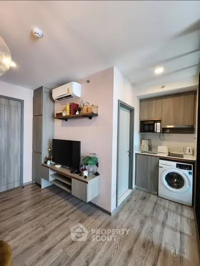 Modern apartment interior with open kitchen and living area featuring wooden flooring and stylish decor.