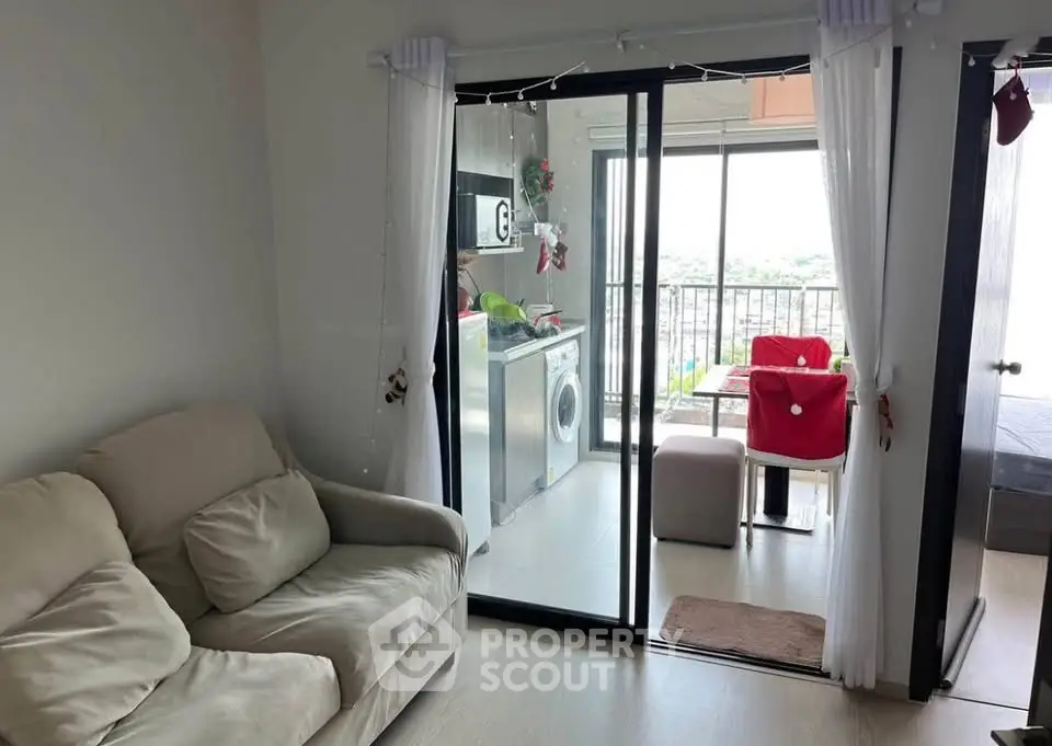 Cozy living room with sliding glass doors leading to a bright balcony and modern kitchen.