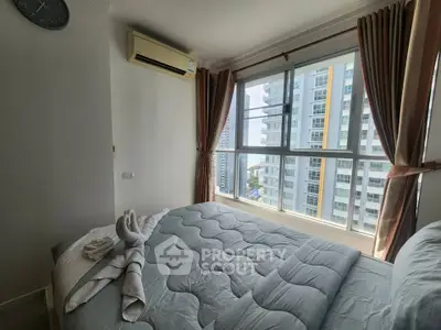 Bright bedroom with large window offering stunning city view, featuring cozy bedding and air conditioning.