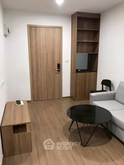 Modern living room with wooden flooring, sleek furniture, and a minimalist design.