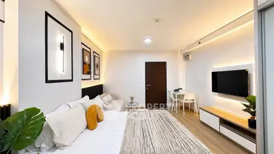 Modern studio apartment with stylish decor and open layout, featuring cozy bed and sleek furniture.
