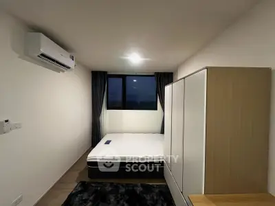 Modern bedroom with minimalist design, featuring a large wardrobe and air conditioning unit.