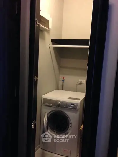 Compact laundry area with modern washing machine in a cozy apartment setting.