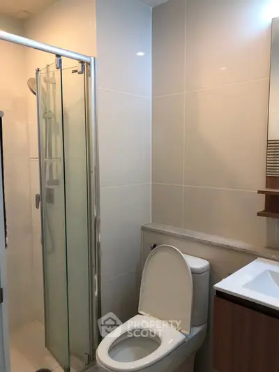 Modern bathroom with sleek shower and toilet in contemporary apartment.
