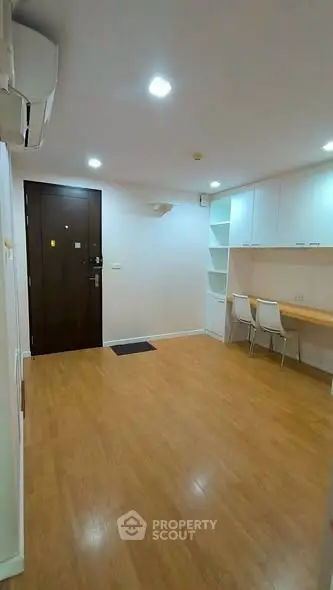 Modern apartment entrance with wooden flooring and built-in storage