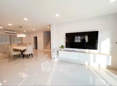 Spacious modern living room with large TV and elegant dining area