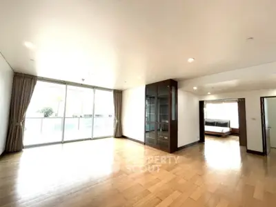Spacious modern living room with large windows and wooden flooring