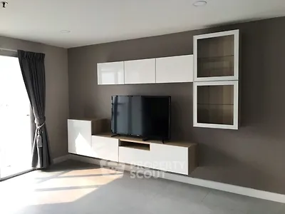 Modern living room with sleek TV unit and natural light