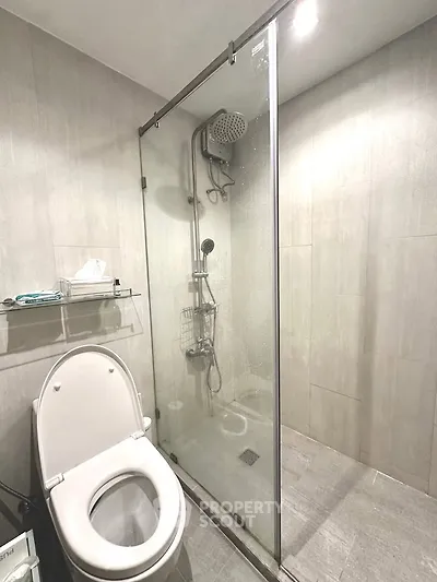 Modern bathroom with glass shower enclosure and sleek fixtures.