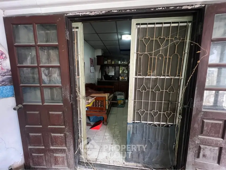 Charming rustic entrance with wooden doors leading to a cozy interior, perfect for a quaint home setting.