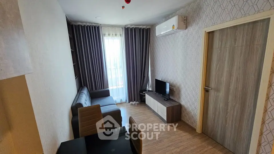 Modern living room with stylish decor, featuring a cozy sofa, TV, and elegant curtains.
