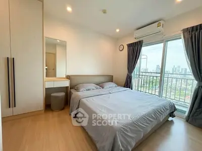 Modern bedroom with city view and balcony access in high-rise apartment