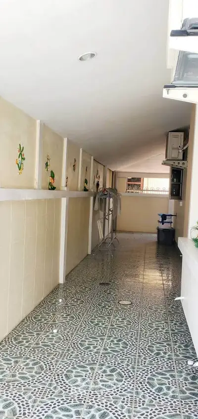 Spacious tiled corridor with decorative wall tiles and ample natural light.