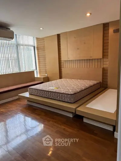 Spacious bedroom with modern design and large windows for natural light.