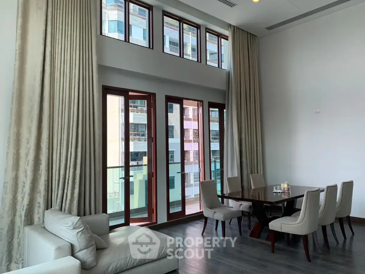 Spacious living room with high ceilings and elegant dining area in modern apartment