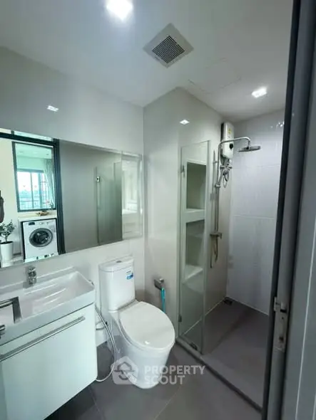 Modern bathroom with shower and washing machine view