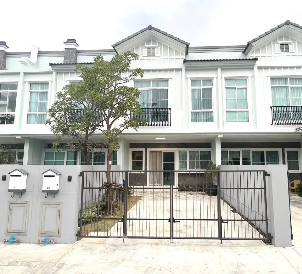 Charming townhouse exterior with gated entrance and lush greenery, perfect for modern family living.