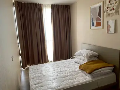 Cozy bedroom with modern decor and natural light through large window.