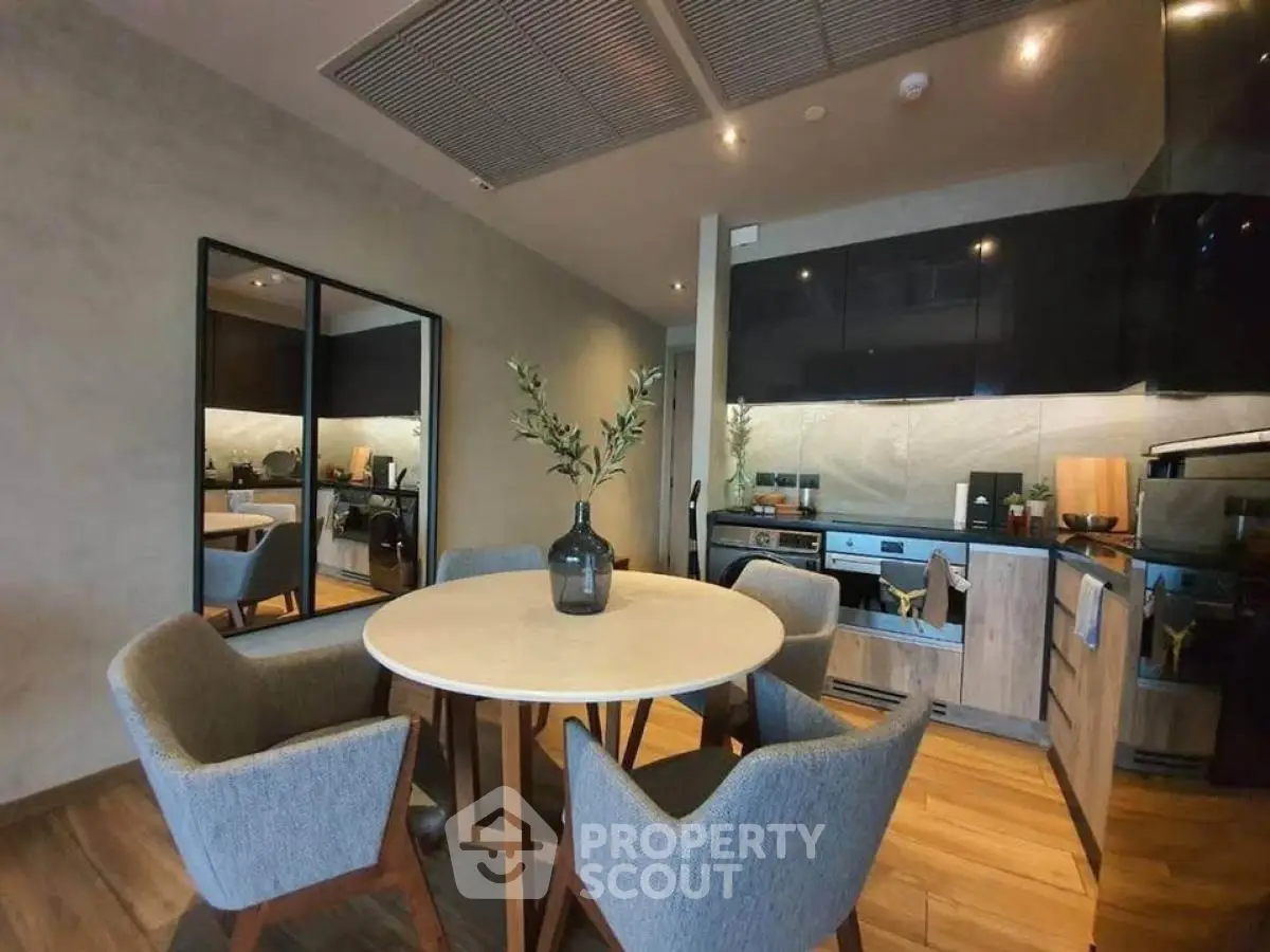 Modern kitchen with dining area featuring sleek cabinetry and stylish decor.