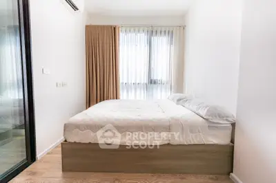 Modern minimalist bedroom with natural light and wooden flooring