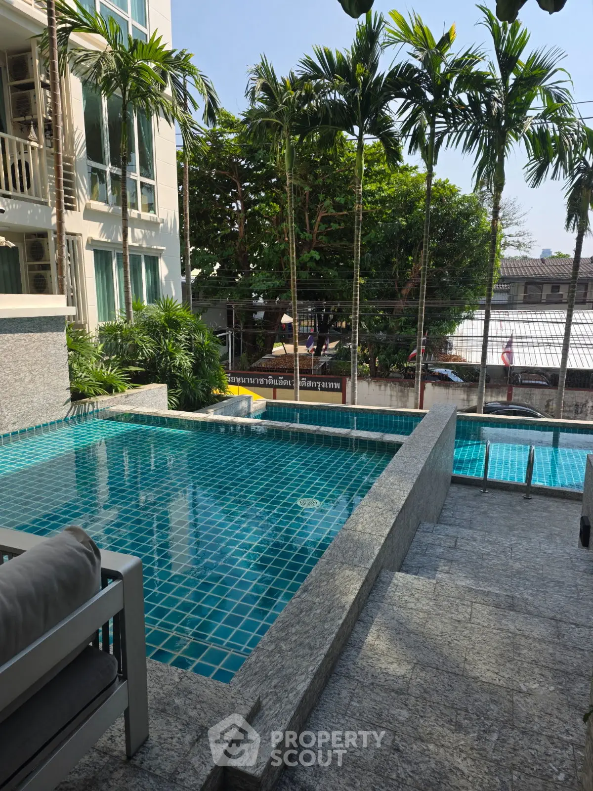 Luxurious poolside view with palm trees and modern architecture