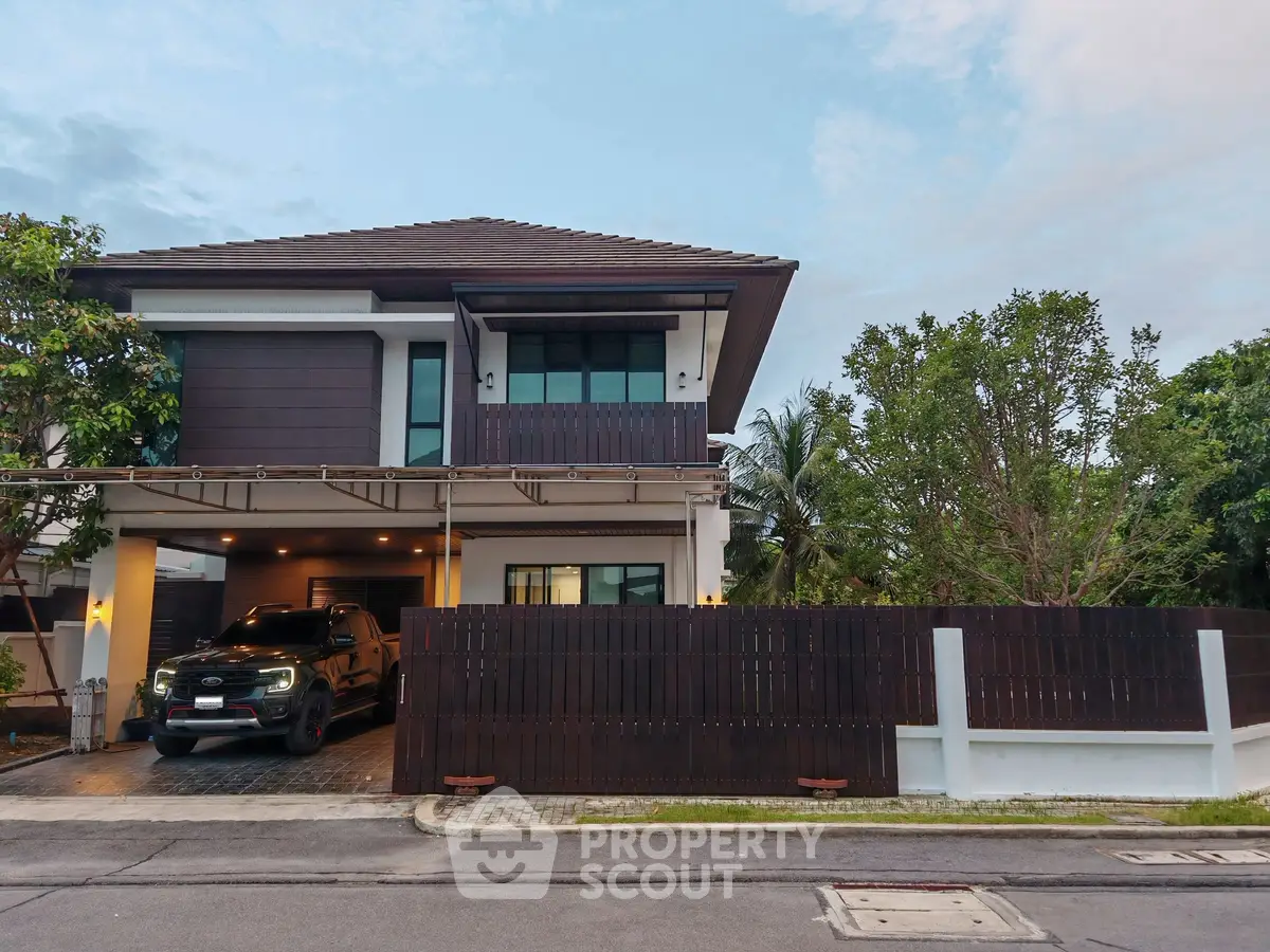 Modern two-story house with spacious driveway and lush greenery, perfect for family living.