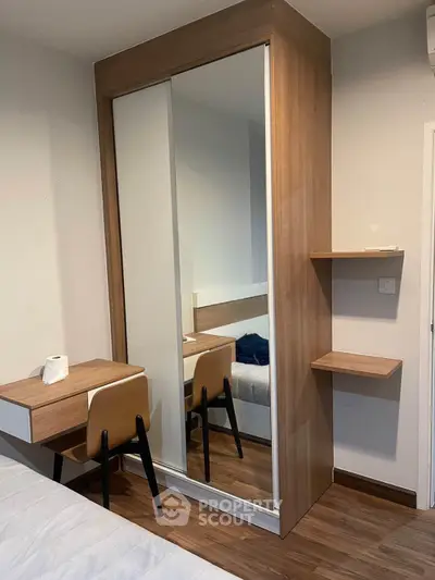 Modern bedroom with sleek wooden wardrobe and cozy workspace