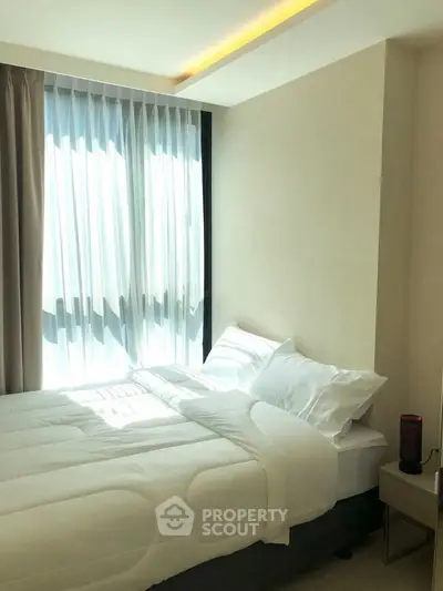 Bright and cozy bedroom with large window and modern decor