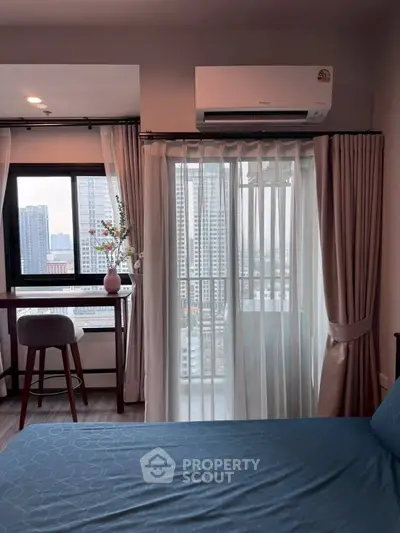 Modern bedroom with city view, featuring a cozy bed, stylish curtains, and a sleek air conditioning unit.