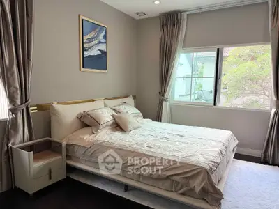 Elegant bedroom with stylish decor and large window offering natural light